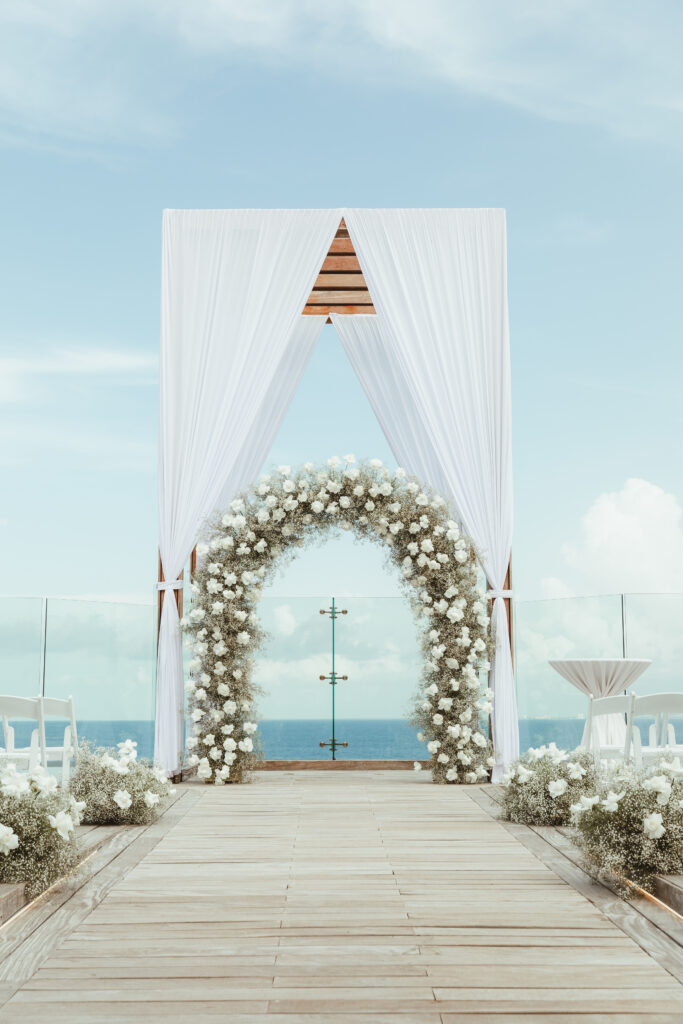 Destination wedding ceremony set up rooftop terrace overlooking ocean in Mexico