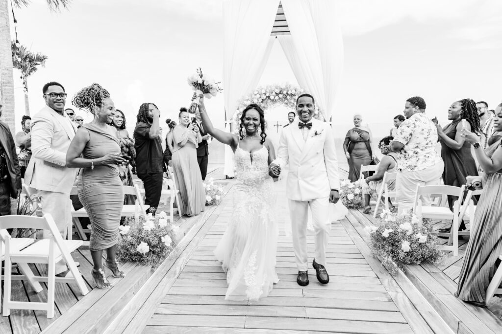 Destination wedding bride & groom in front of wedding ceremony arch in Mexico