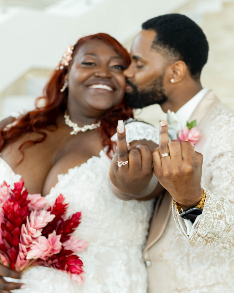 black couple white dress off white suit showing ring fingers